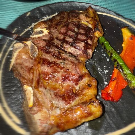 Corte de carne a la brasa servido en Kilú con acompañamientos.