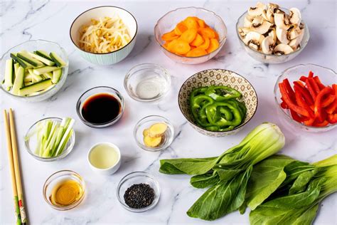 Ilustración variada de ingredientes frescos para Chop Suey, como zanahorias, pimientos, cebolla, champiñones y trozos de carne cruda.