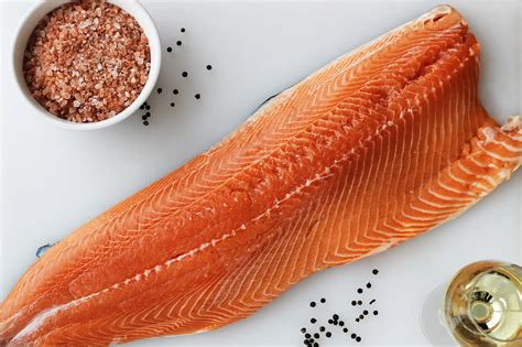 Fotografía técnica: primer plano de un filete de salmón sellado en sartén con piel crujiente y centro jugoso
