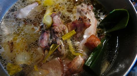 Fotografía de la carne braseándose a fuego lento en una olla con vegetales y hierbas aromáticas