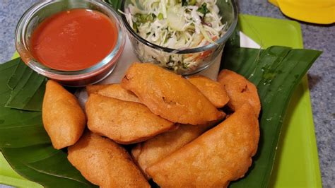 Ilustración de pastelitos de masa salvadoreños recién fritos y dorados, servidos con curtido y salsa.