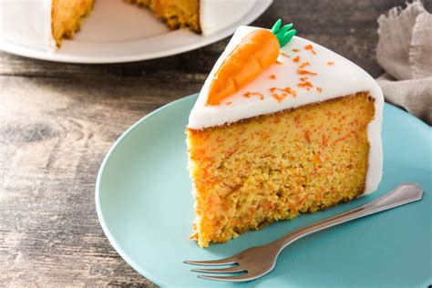 Proceso de montaje de un pastel de zanahoria, mostrando cómo se aplica el frosting entre las capas.