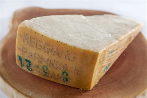 Foto de un trozo de Parmigiano Reggiano con el sello DOP visible