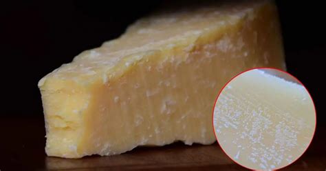 Fotografía detallada de un cuchillo tipo lágrima extrayendo lascas de un queso curado