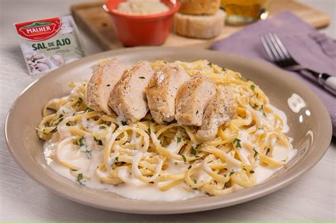 Foto de plato de fideos tricolor con salsa Alfredo cremosa y trozos de pollo dorado