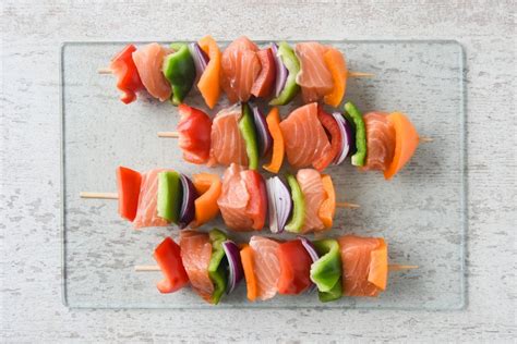 Brochetas de salmón y pimientos de colores en una sartén grill