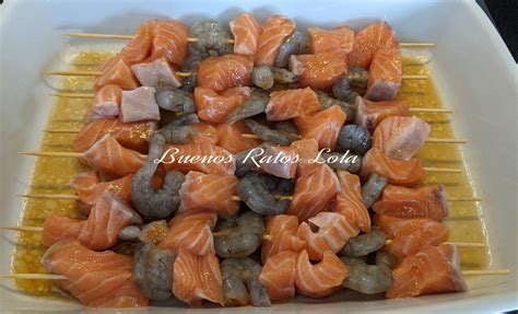Brochetas de salmón y langostinos macerando en una salsa