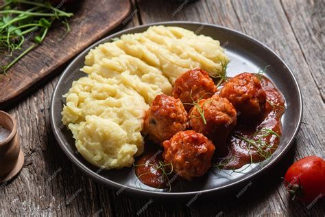 Plato de presentación de albóndigas suecas con puré de patatas y salsa de arándanos.