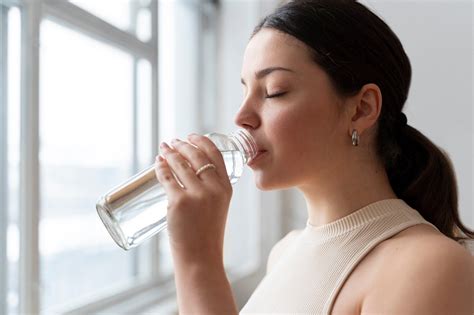 Persona bebiendo agua mientras espera un examen, simbolizando el ayuno