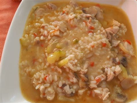 Plato de arroz cremoso junto a jugosos trozos de pollo.