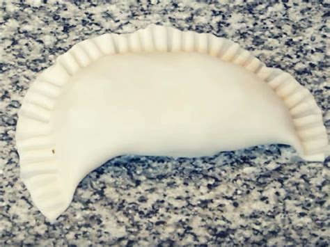 Infografía que muestra los pasos para sellar una empanada con tenedor vs repulgue manual