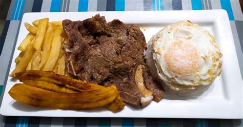 Infografía que muestra los componentes del churrasco a lo pobre: carne, huevo, plátano, papas fritas y ensalada