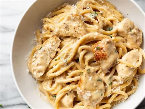 Plato de pasta con pollo y salsa de durazno, con duraznos frescos al lado