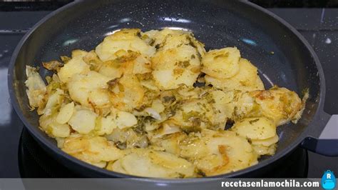 Patatas y cebolla pochándose en una sartén