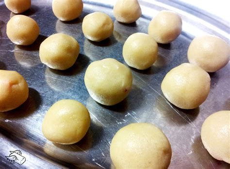Bolas de masa de galleta dispuestas en una bandeja para hornear con espacio entre ellas