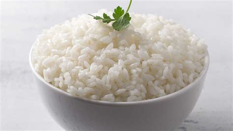 arroz blanco perfectamente cocido y graneado servido como acompañamiento de un plato principal
