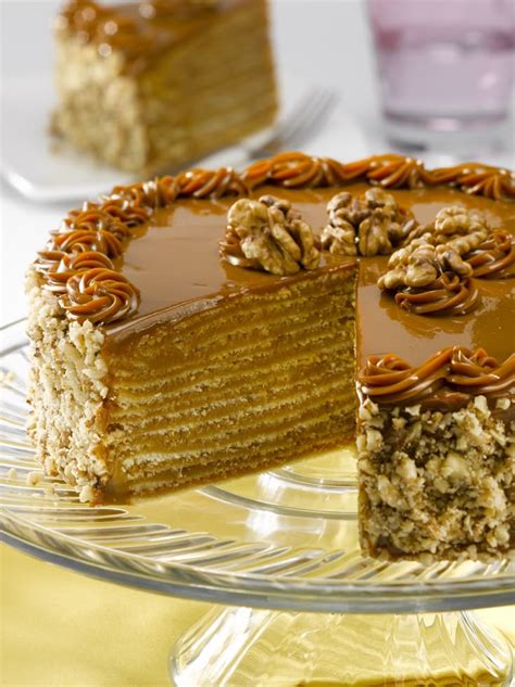 Torta de panqueques con manjar terminada y decorada con rosetones y nueces