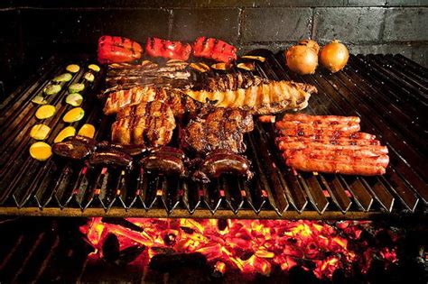 Foto de una parrilla encendida con diferentes tipos de carne cocinándose