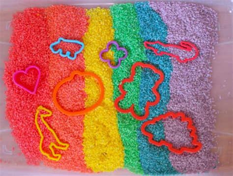 Bandejas con arroz de colores secándose sobre papel de cocina.