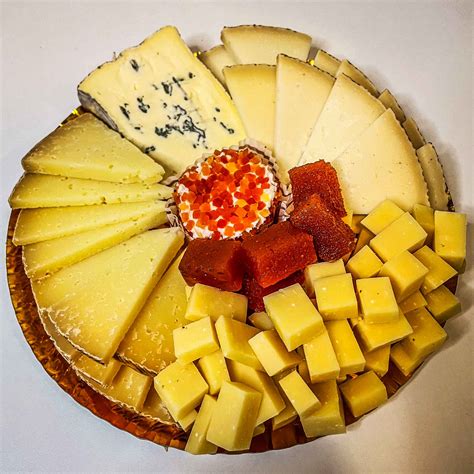 Imagen de una tabla de quesos variados con diferentes tipos de vino