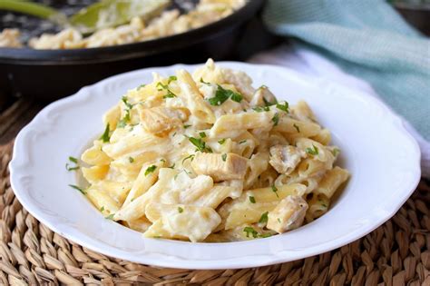Sartén con macarrones con pollo, queso fundido y un toque de mantequilla de hierbas