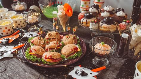 Mesa decorada para fiesta infantil con comida temática dispuesta en niveles para mayor dinamismo