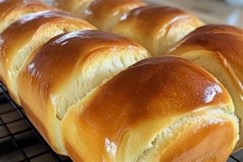 Imagen de un pan de leche esponjoso con cortes decorativos en la parte superior.