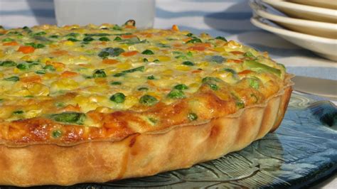Molde con masa de tarta cubierto con papel de hornear y relleno de legumbres para el horneado a ciegas.