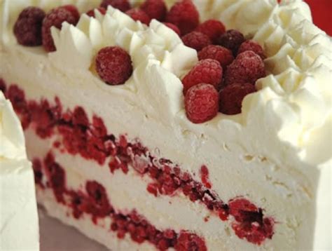 Tarta vienesa de frambuesa decorada con merengue y nueces picadas.