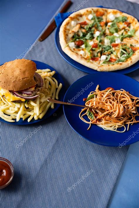 Composición de diferentes platos: hamburguesa, pizza, espaguetis