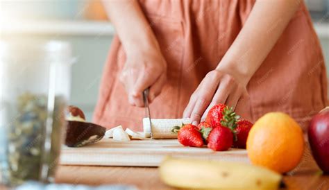Manos cortando frutas frescas en una cocina profesional