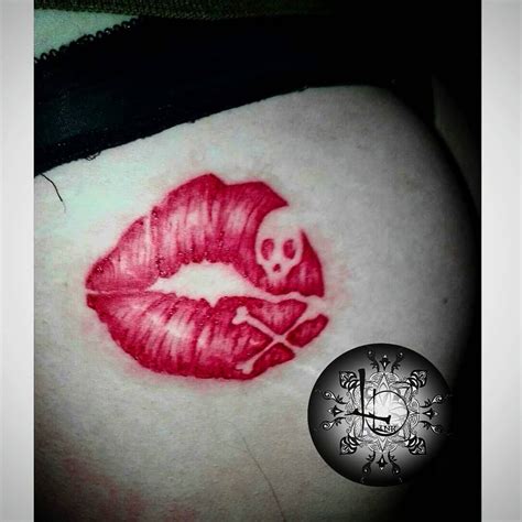 Tatuaje de calavera con labios rojos simulando un beso.