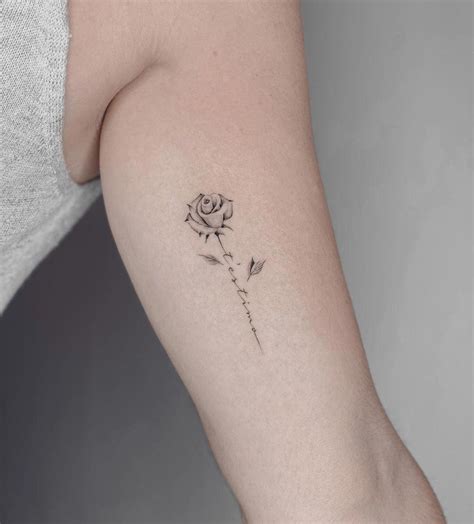 Detalle de un tatuaje de rosa realista en el brazo.