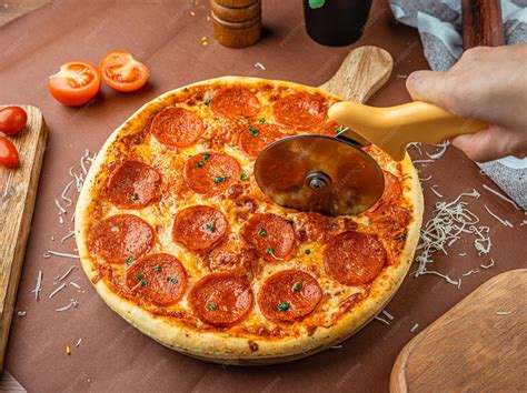 Foto de una pizza recién horneada siendo cortada
