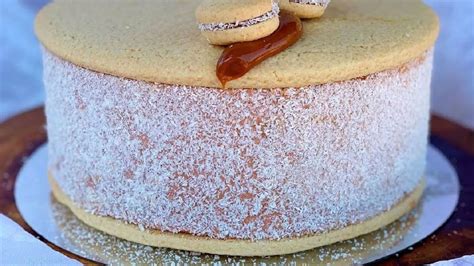 Persona disfrutando un pedazo de torta de alfajor con un centro suave