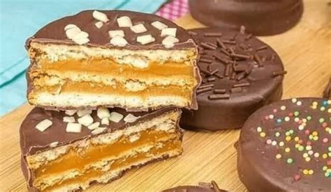 Ilustración de capas de masa de alfajor estirada sobre papel de horno, apiladas y refrigerándose