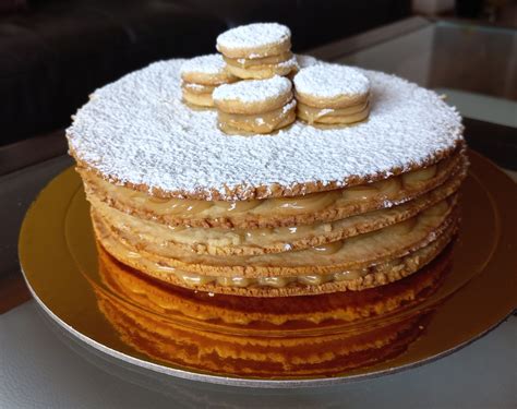 Torta de alfajor con capas visibles de galleta y manjar, sin cobertura
