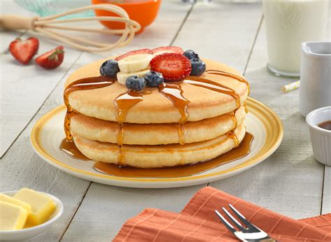 foto de hot cakes esponjosos con avena, cubiertos con fruta fresca y un chorrito de miel de maple