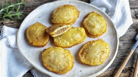Plato de patatas de Olot servidas con guarnición de ensalada, mostrando su textura dorada y crujiente.