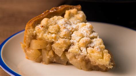 Ilustración de un crumble de manzana y pera dorado y burbujeante, recién salido del horno, con una porción servida en un plato.