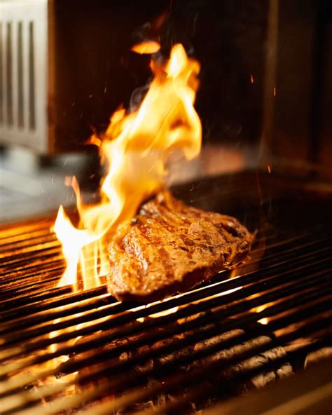 Foto de parrilla con brasas al punto y cebolla frotando la rejilla