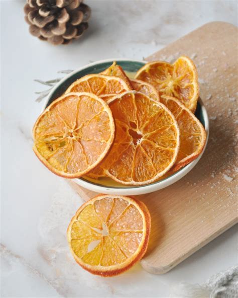 Centro de mesa aromático con piñas, rodajas de naranja y romero