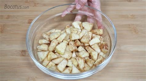 Primer plano de manzanas troceadas y mezcladas con especias y azúcar