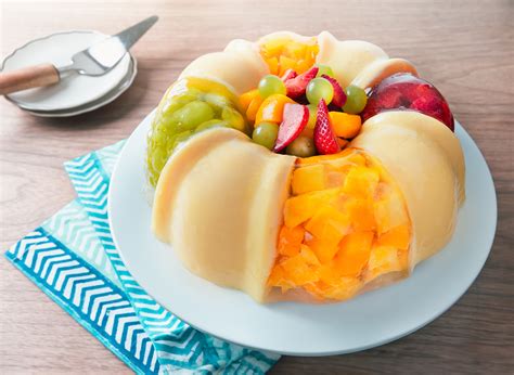 Variedad de gelatinas decoradas con frutas, frutos secos y crema batida.