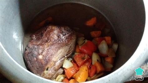 Imagen de una mesa servida con bondiola a la cacerola, acompañada de puré de batatas y una ensalada verde.