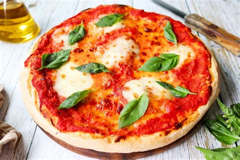 Fotografía de una pizza Margarita clásica, destacando sus colores rojo, blanco y verde.