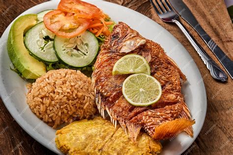 Imagen de un plato de arroz con gambas y trozos de pescado, acompañado de una ensalada fresca.