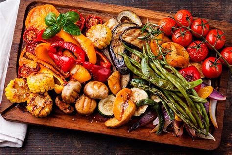 Plato de verduras asadas y carnes en una bandeja de horno, mostrando el dorado y la caramelización.