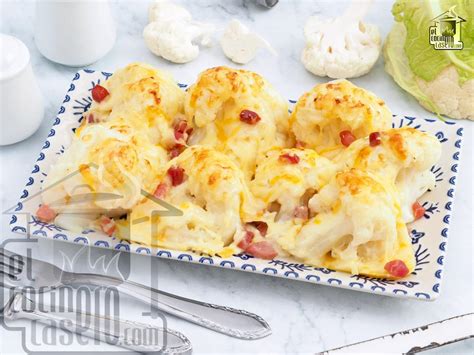 Plato servido con croquetas de coliflor doradas al horno acompañadas de una salsa de yogur y hierbas frescas.