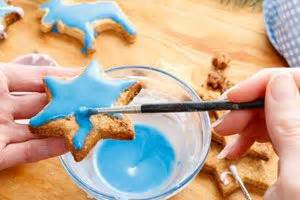 Niños decorando galletas con pintura comestible